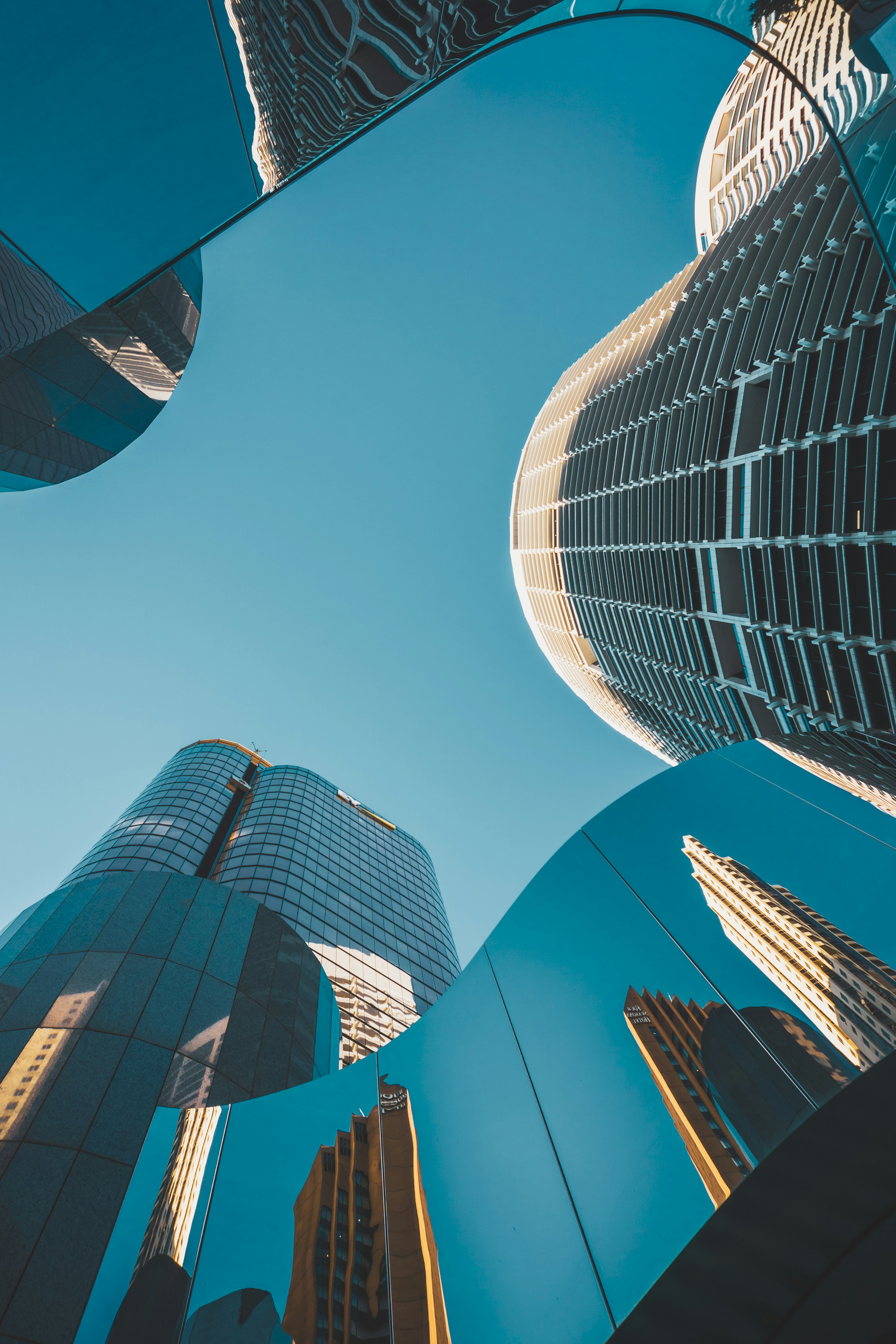 Architecture contemporaine en hauteur — gratte-ciel aux reflets miroir bleu profond