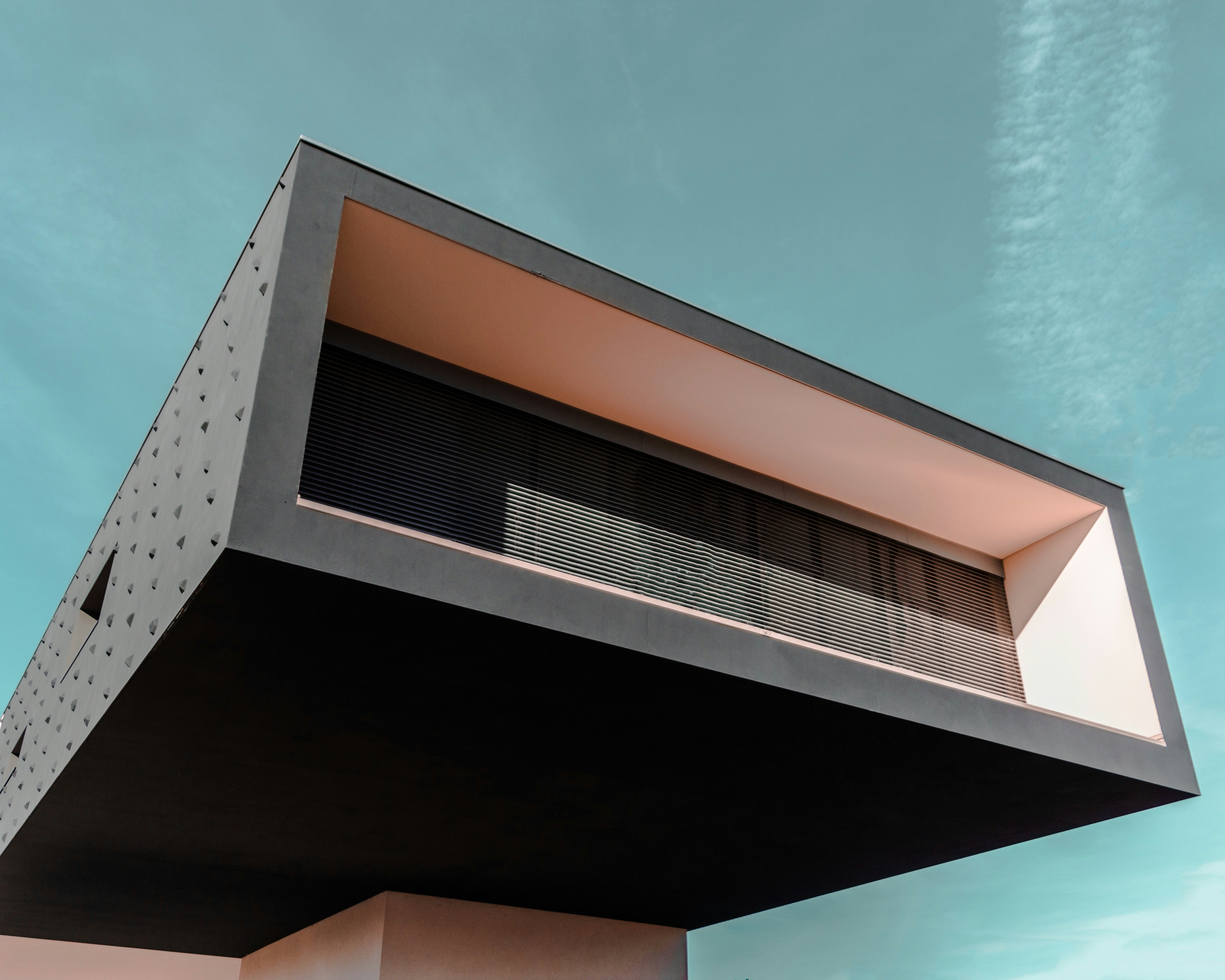 Architecture contemporaine — volume en porte-à-faux suspendu sous un ciel d'altitude